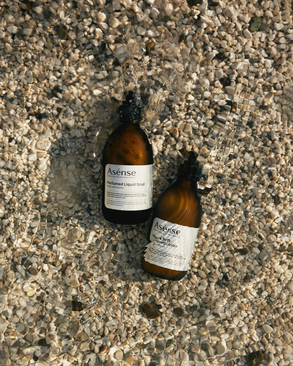 Asense bottles on a pebble beach