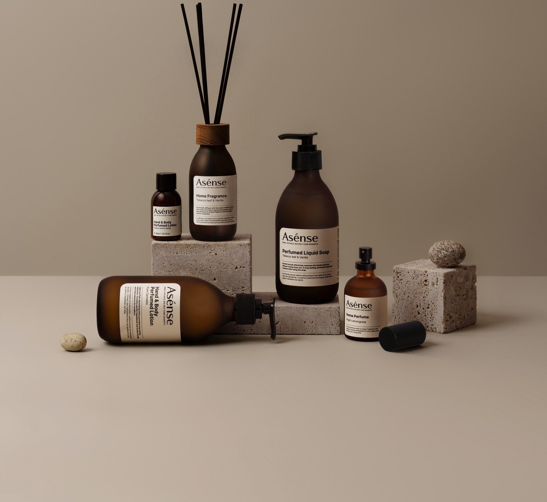 Asense bottles and a reed diffuser on a beige set